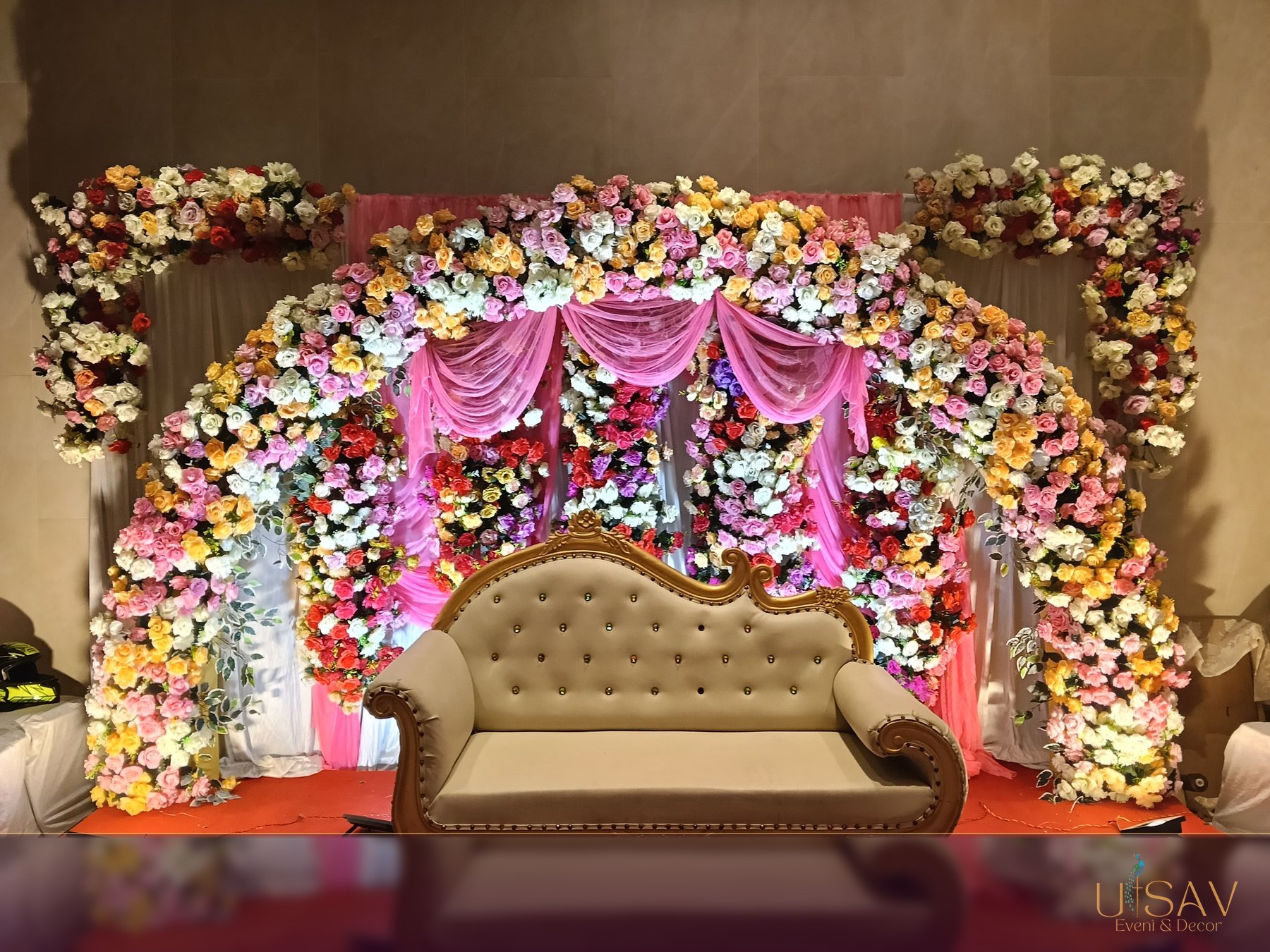 Pink floral celebration stage with ornate sofa